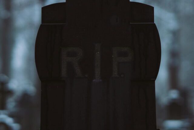 A close-up of a gravestone with RIP inscription in a quiet cemetery setting.